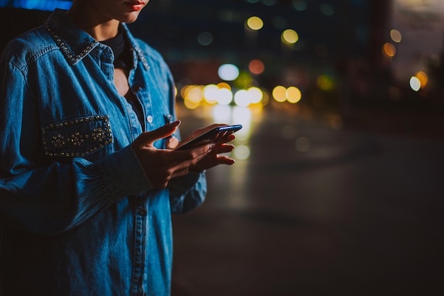 midsection of man using mobile phone at night