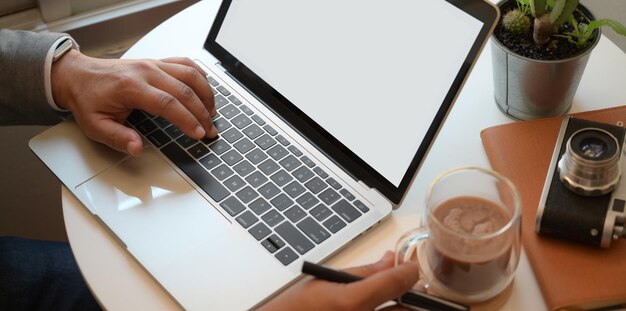 Midsection of man using mobile phone on table