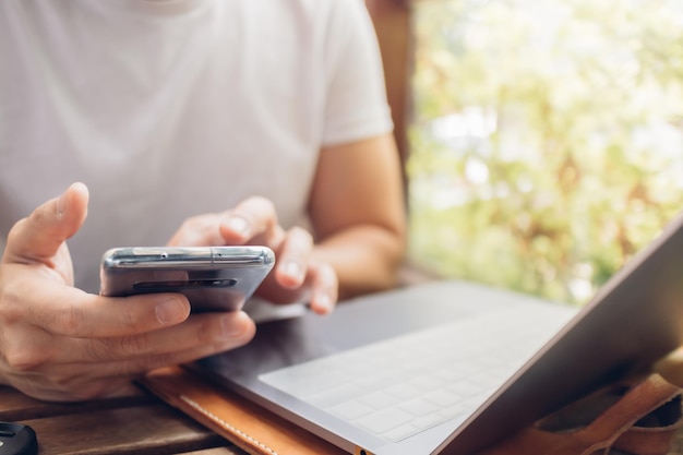 Midsection of man using mobile phone on table