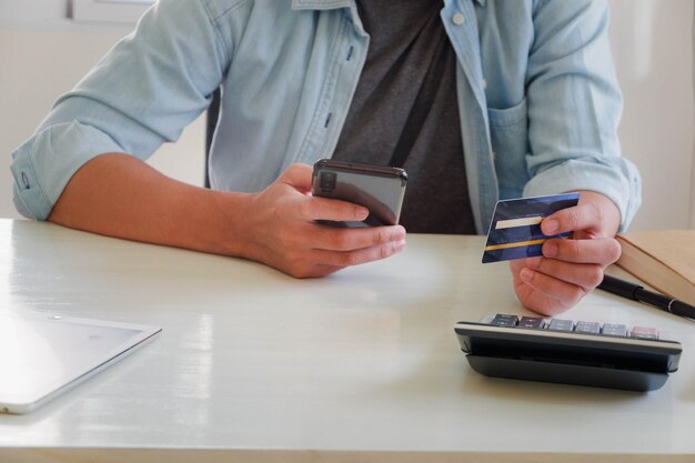 Midsection of man using mobile phone on table