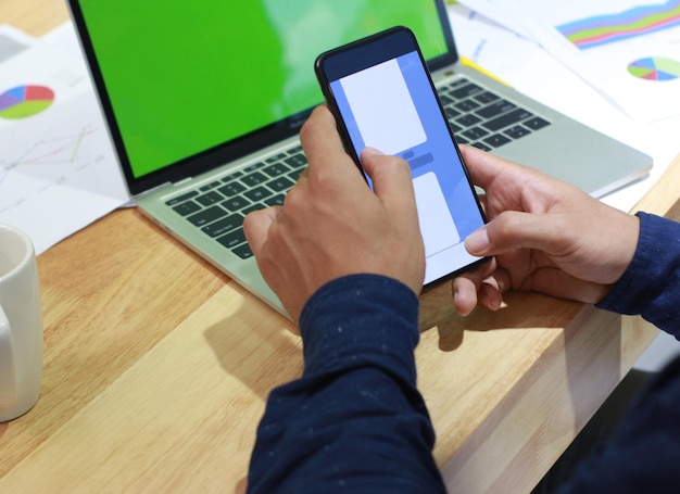 midsection of man using mobile phone on table