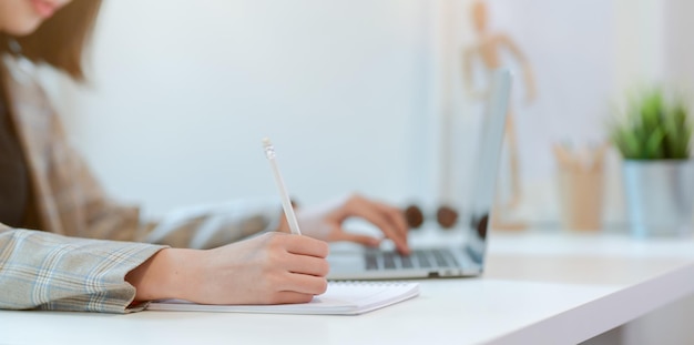 Midsection of man using mobile phone while sitting on table