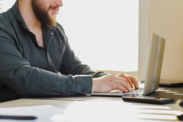 Photo midsection of man using mobile phone while sitting on table