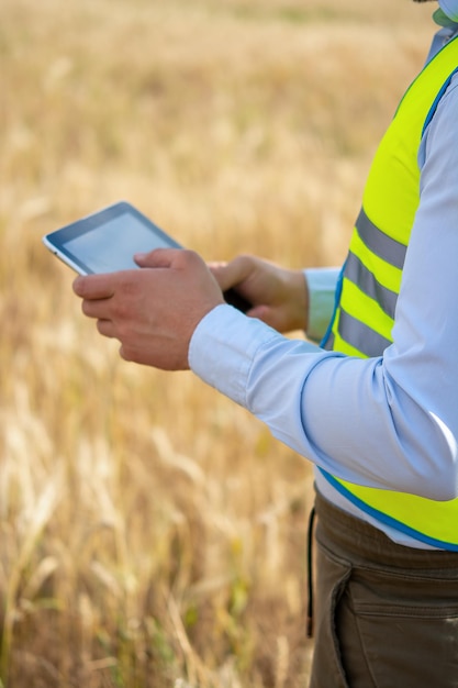 Photo midsection of man using mobile phone while standing on field