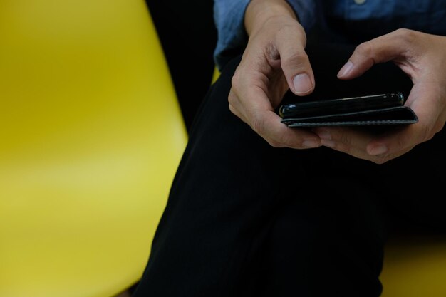 Midsection of man using mobile phone