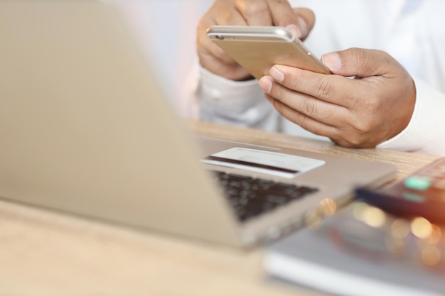 Midsection of man using smart phone on table