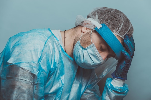 midsection of man wearing mask against blue background