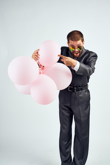Midsection of man with balloons against white background