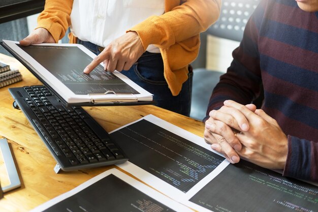 Photo midsection of man with colleague holding document at office