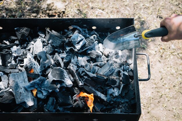 Foto sezione centrale di un uomo con il fuoco sulla griglia da barbecue