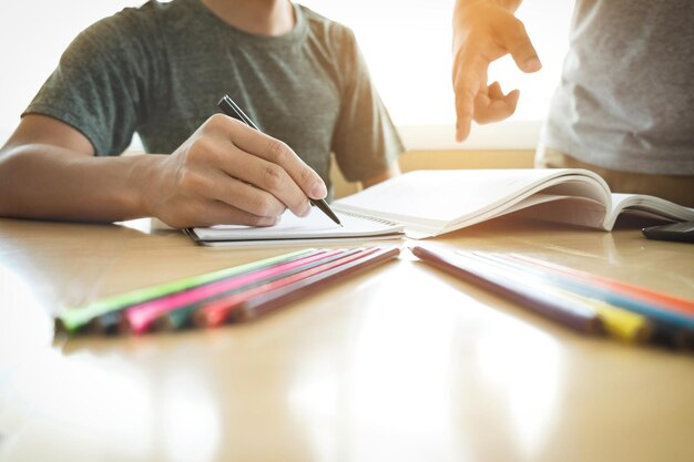 Foto sezione centrale di un uomo con un amico che studia al tavolo