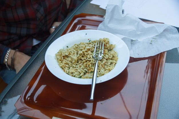 Foto sezione centrale di un uomo con i tagliatelle a tavola