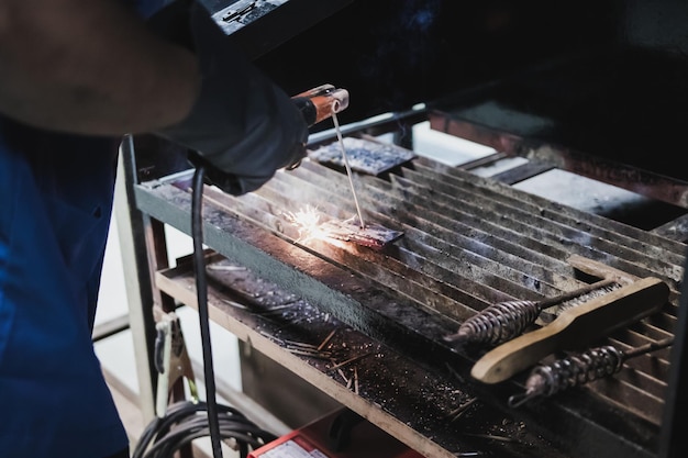 Midsection of man working on barbecue grill