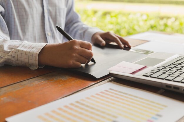 Photo midsection of man working on table in office