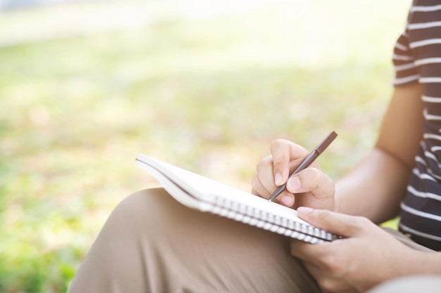 Midsection of man writing in note pad