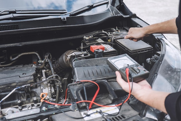 Photo midsection of mechanic checking battery of car