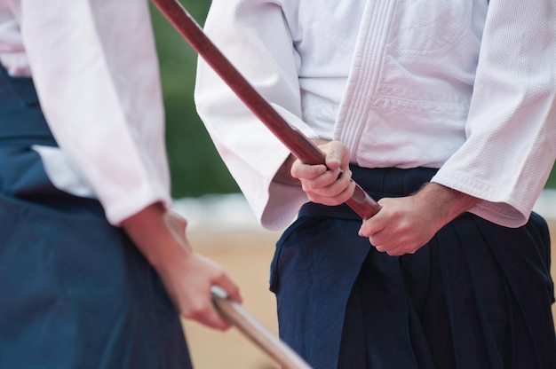 Photo midsection of men holding sticks