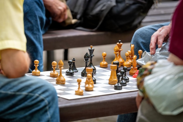 midsection of men playing chess on board