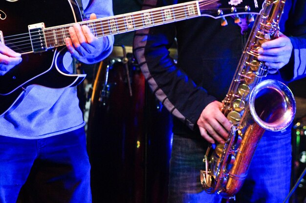 Photo midsection of men playing musical instrument