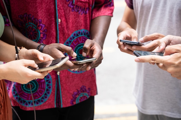 Photo midsection of men and woman holding mobile phones