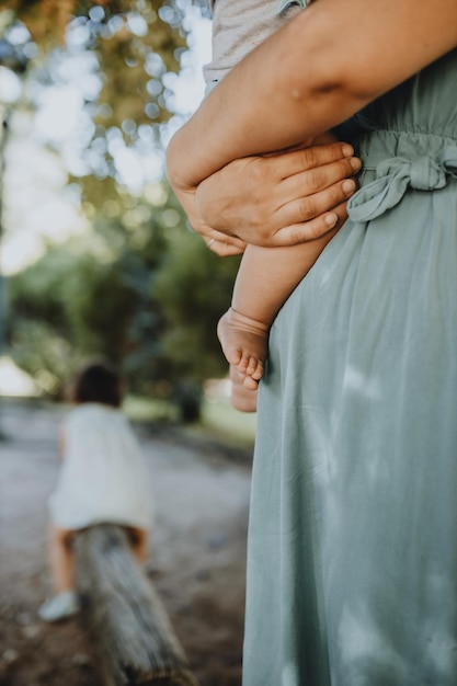 Foto sezione centrale di una madre che porta un bambino nel parco