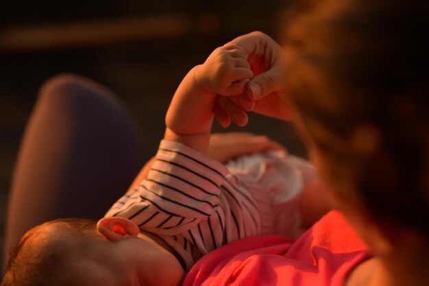 Midsection of mother sitting with toddler during sunset