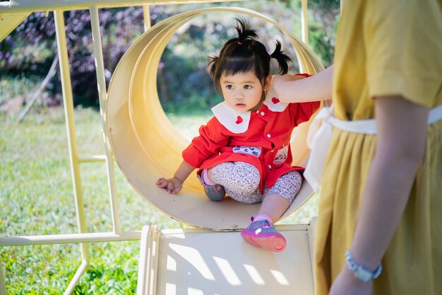 Midsection of mother with cute girl playing at playground