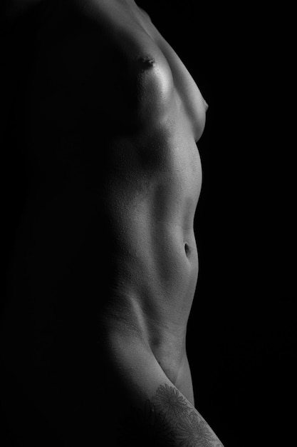 Photo midsection of naked woman against black background