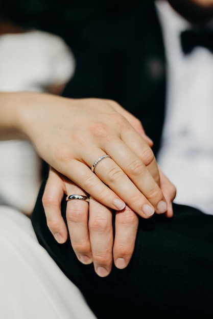 midsection of newlywed couple holding hands in wedding ceremony