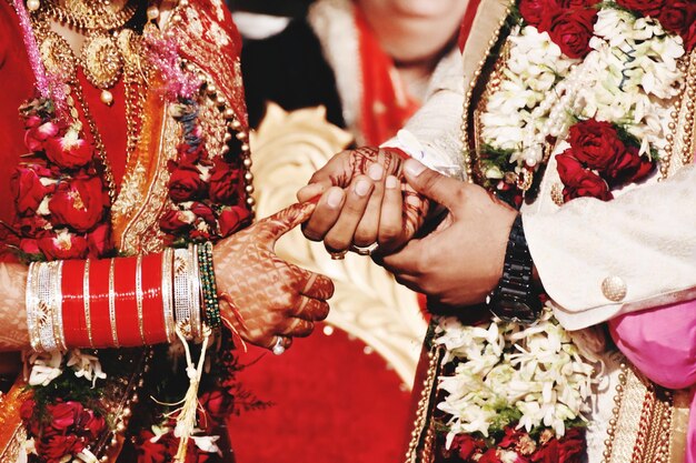 Midsection of newlywed couple holding hands in wedding