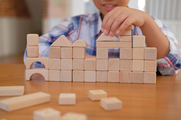 写真 家でテーブルの上の玩具ブロックで遊んでいる男の子のミッドセクション