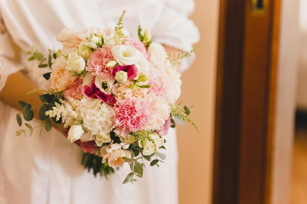 写真 花束を握っている花嫁の真ん中