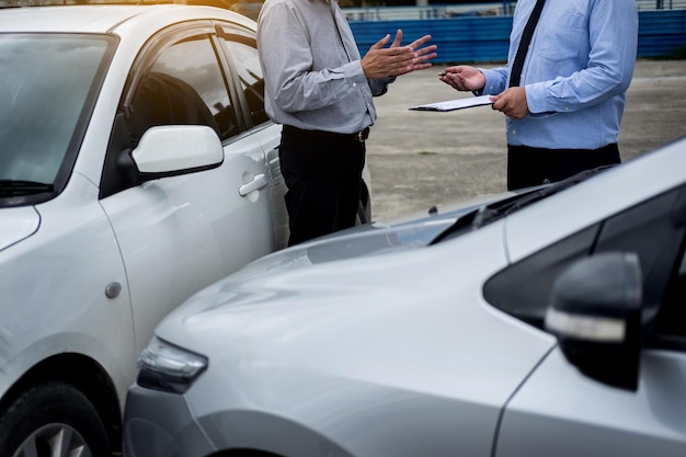 写真 路上で車のそばに立って男と話しているビジネスマンのミッドセクション