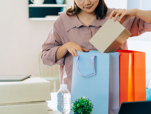 Фото Средний раздел бизнесменки, кладущей коробки в сумки для покупок