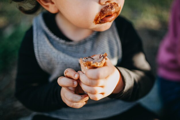 写真 チョコレートアイスクリームを食べている子供の真ん中