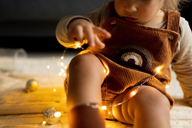 写真 ストリングライトを持つ子どもの中間部分