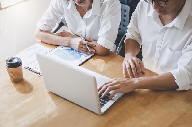 写真 男性と女性がテーブルでラップトップで話し合っているミッドセクション