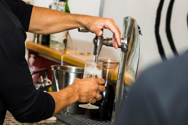 写真 グラスでビールを飲んでいる男の中間部分