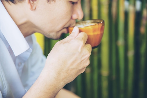 写真 カップでコーヒーを飲んでいる男の真ん中