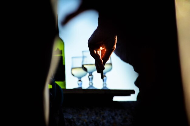 写真 天空を背景にワインを飲んでいる男のミッドセクション
