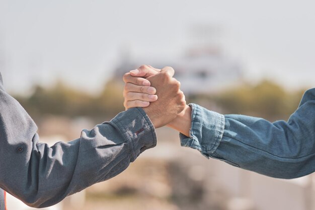 写真 ぼんやりした背景に手をつないでいる男の真ん中