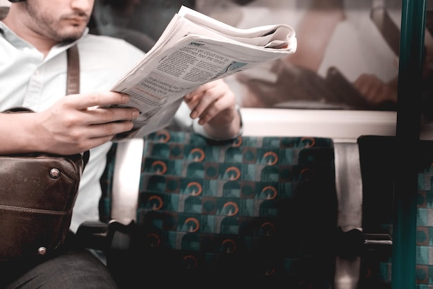 사진 좌석 에 앉아 신문 을 읽는 사람 의 중간 부분