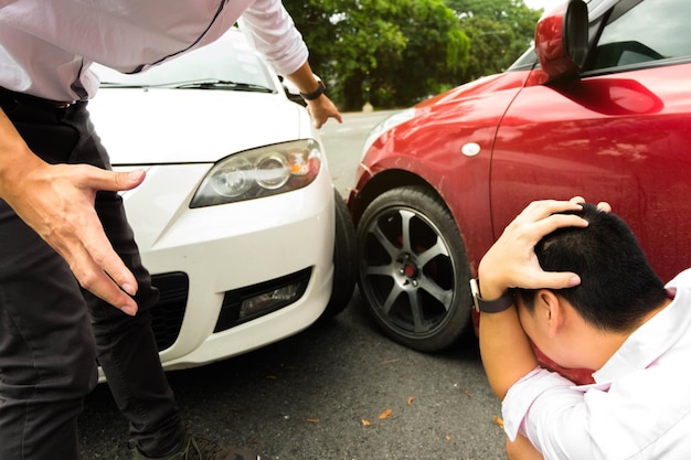 写真 男性に衝突した車を見せている男性のミッドセクション