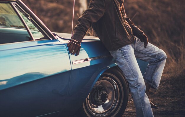 写真 車のそばに立っている男の真ん中