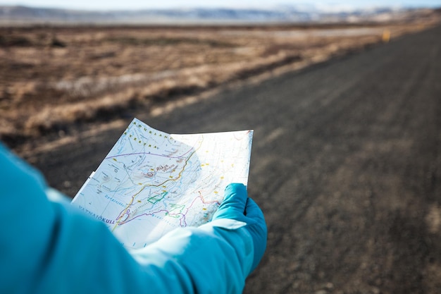 写真 道路で地図を握っている人の中間部分