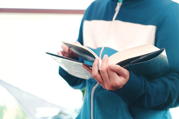 写真 屋内で本を読んでいる人の中間部分