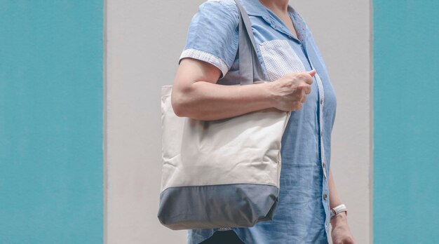 Живот женщины больших размеров с многоразовой холщовой экологически чистой сумкой за пределами супермаркета