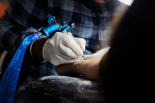 Фото Средняя часть татуировщика, делающего татуировку