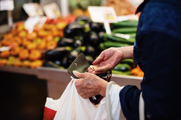 写真 市場で野菜を買う女性の中央部分