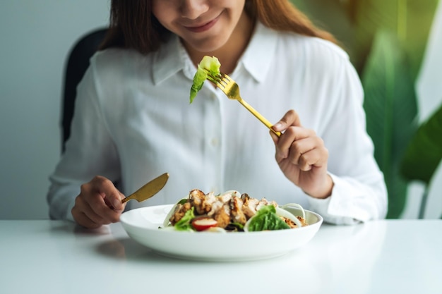 写真 皿で食べ物を食べている女性の中央部分